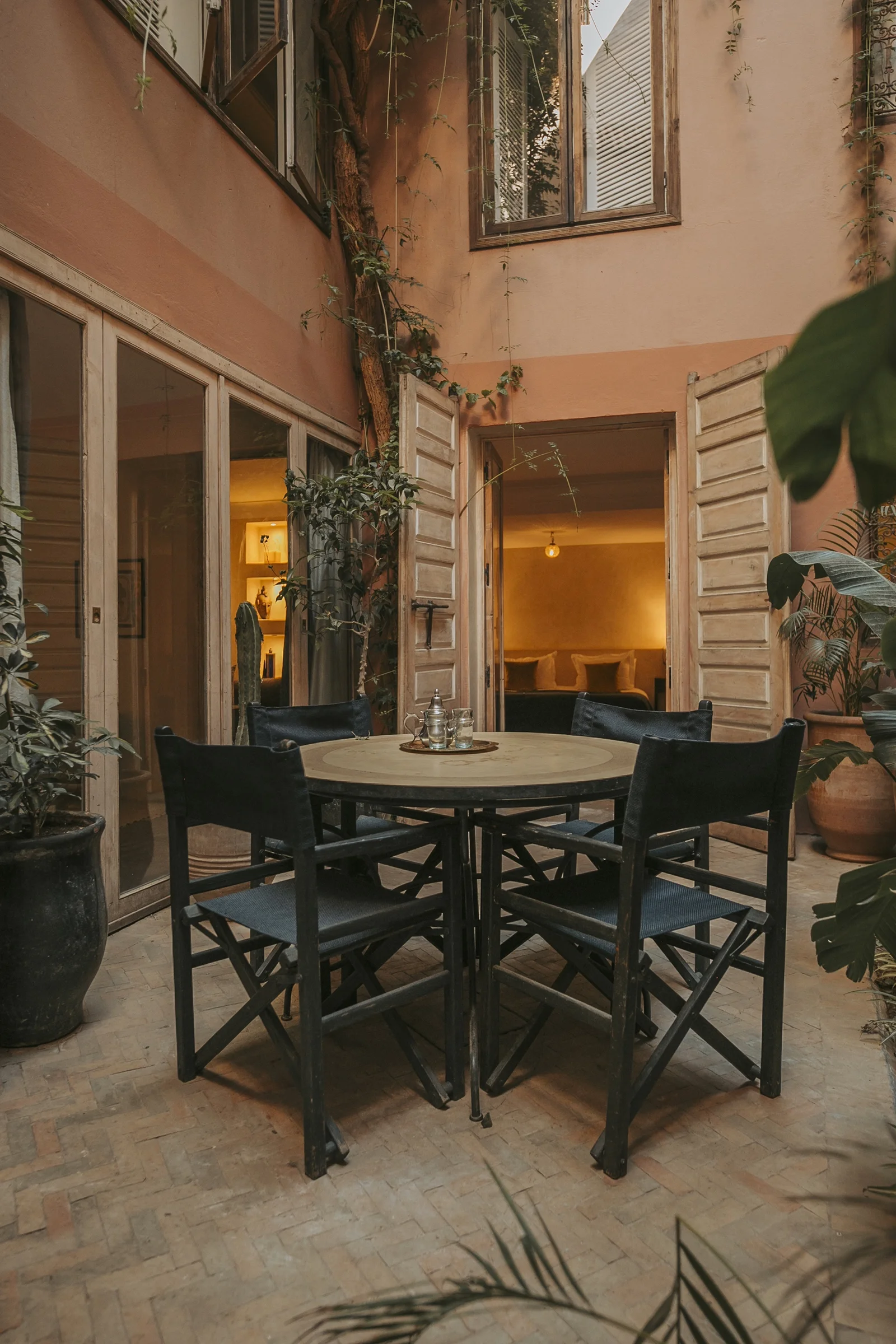 The sunlit patio of Dar Zelda in portrait — arcades and greenery around the fountain