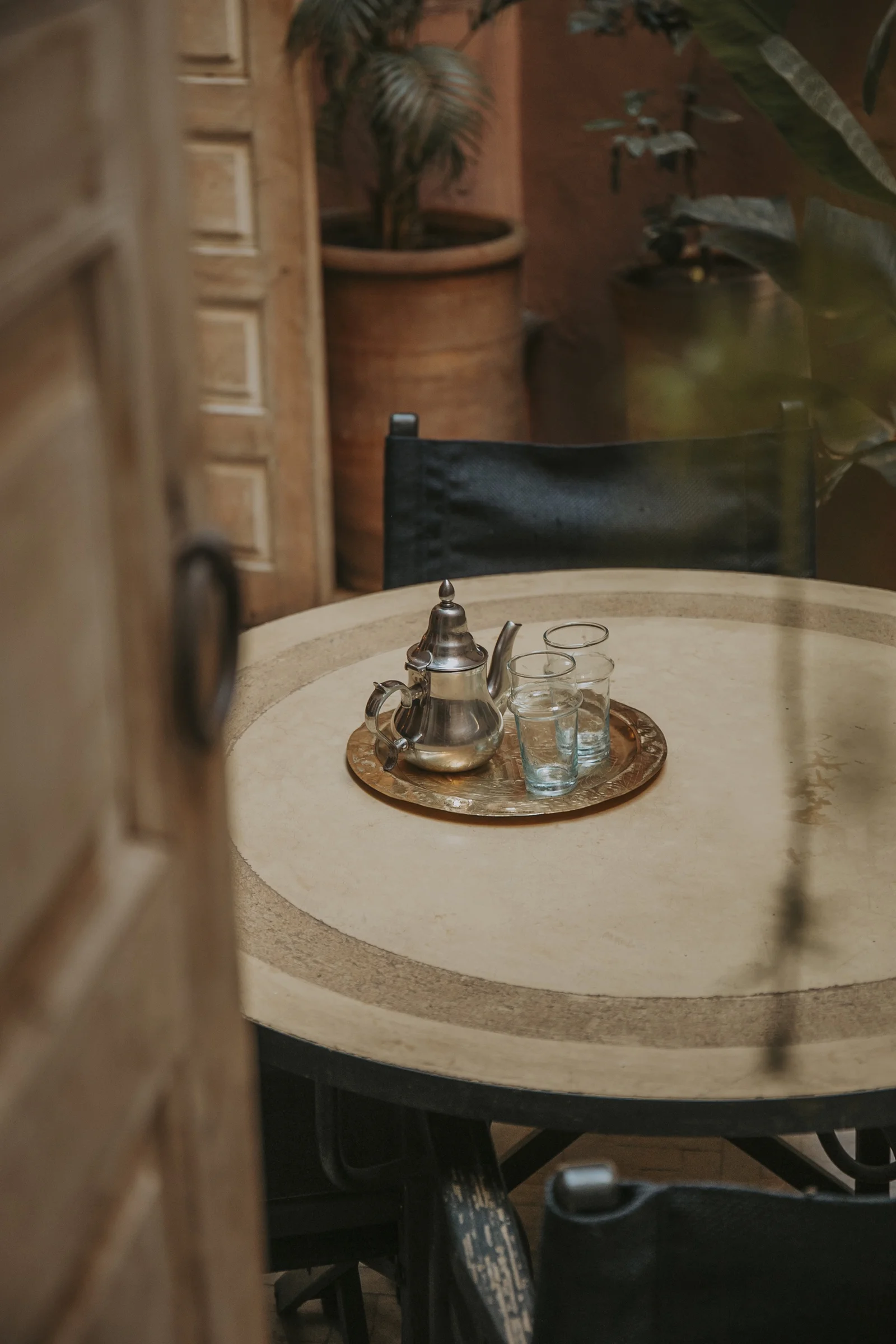 A brass teapot on a stone table at Dar Zelda — tea served in the patio