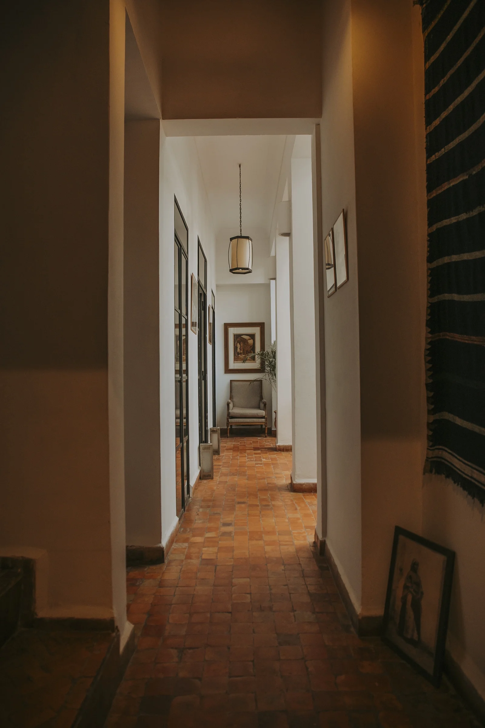 A corridor of the house hung with framed works — the collection along the walls