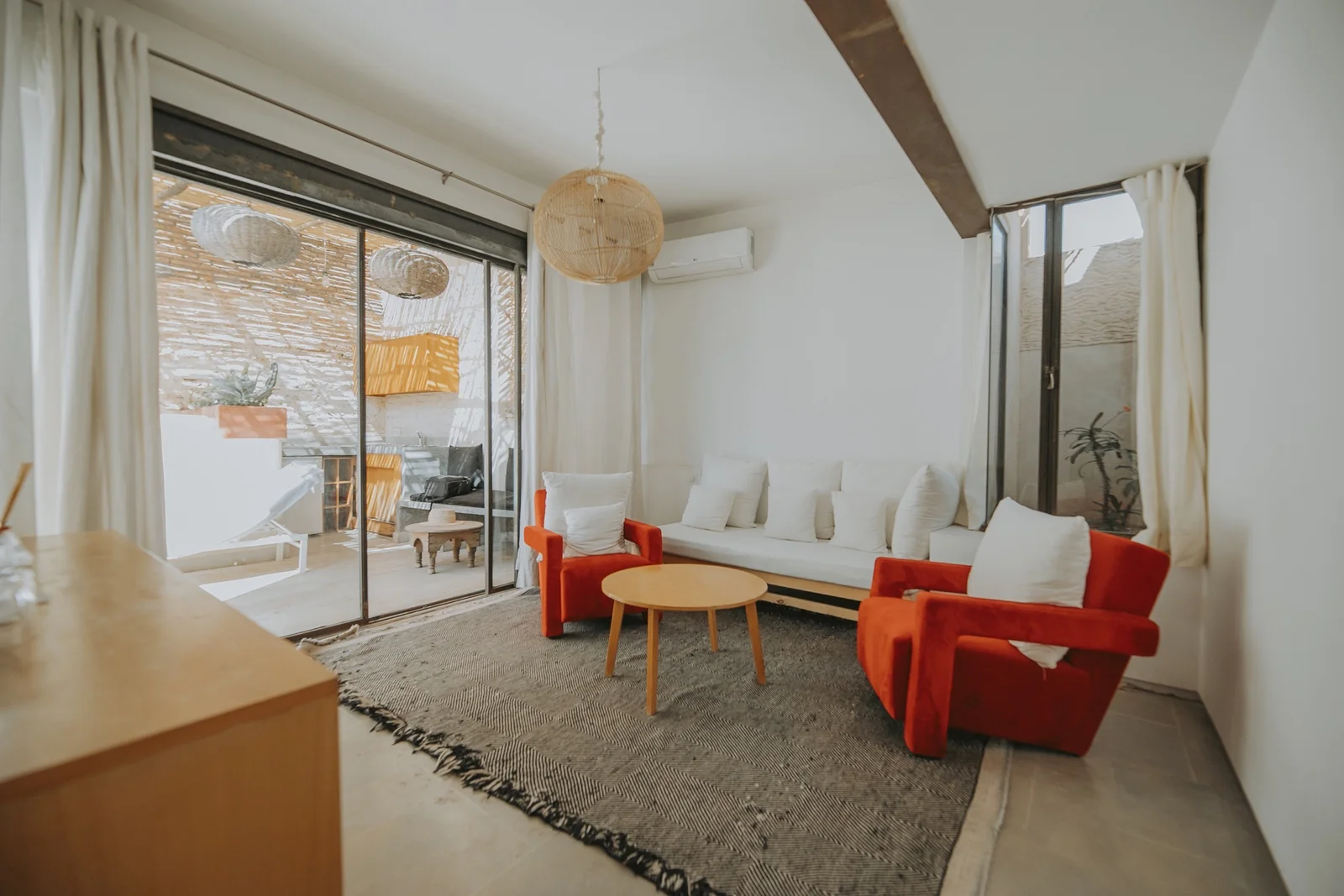A white living room of Dar Zelda opening onto its terrace