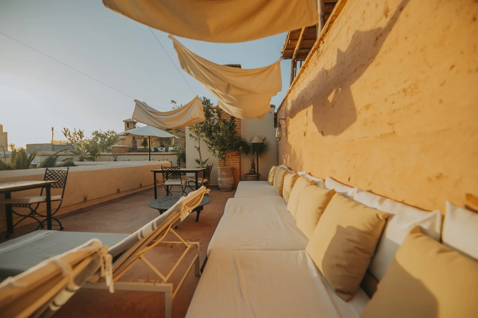 The rooftop lounge of Dar Zelda under its canvas awnings, cushions in the low sun