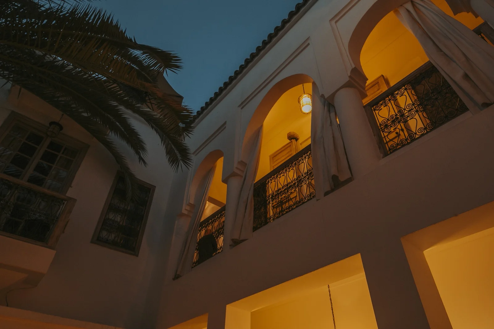 The arcades of Dar Zelda's patio lit at night — the house dressed for an evening
