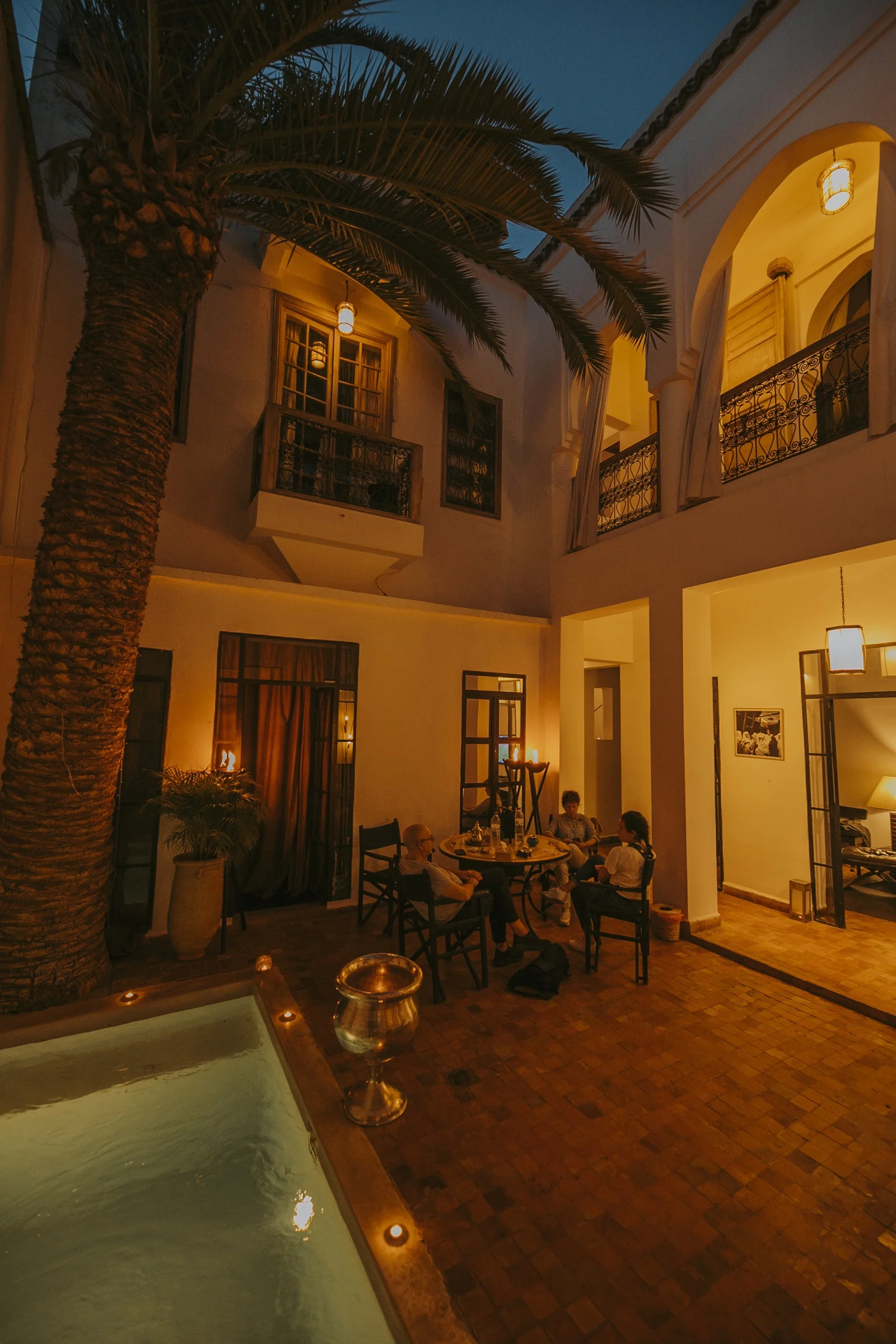 The heated pool of Dar Zelda by candlelight, the evening gathered around the water